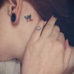 Фото тату: маленькая буква "W" и сердечко на затылке девушки. Нежные и минималистичные рисунки татуировок.