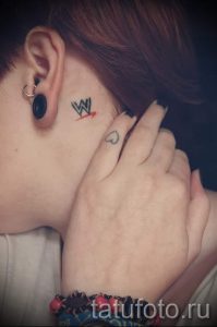Фото тату: маленькая буква "W" и сердечко на затылке девушки. Нежные и минималистичные рисунки татуировок.