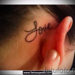 Фото тату: маленькая надпись "Love" каллиграфическим шрифтом на затылке девушки. Нежный и романтичный рисунок татуировки.