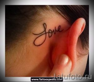 Фото тату: маленькая надпись "Love" каллиграфическим шрифтом на затылке девушки. Нежный и романтичный рисунок татуировки.