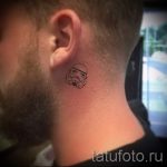 Фото тату: миниатюрный штурмовик из Звездных войн на затылке у мужчины. Детализированный рисунок татуировки, выполненный в технике лайнаворк.