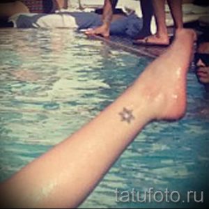 Фото тату маленькой звездочки на лодыжке. Простой и изящный рисунок татуировки в черно-белом цвете.
