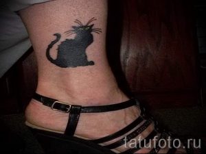 Фото тату черного кота на лодыжке. Простой, но стильный рисунок татуировки, выполненный в минималистичном стиле.