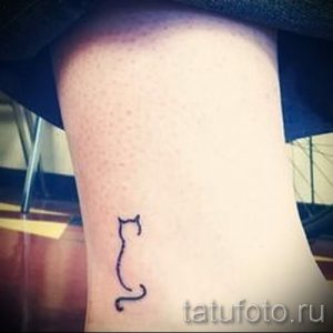 Фото тату на лодыжке: минималистичный силуэт кошки, выполненный одной тонкой линией.