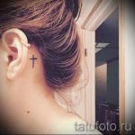 Фото тату маленького черного креста на затылке. Простой и элегантный рисунок татуировки, выполненный в минималистичном стиле.