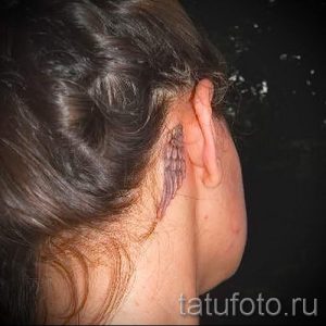 Фото маленькой татуировки крыла на затылке, выполненной в черном цвете. Простой и элегантный рисунок для девушек, подчеркивающий нежность.