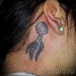 Фото тату с изображением небольшого ловца снов на задней части шеи. Рисунок татуировки выполнен в черно-серых тонах с детальной проработкой элементов.
