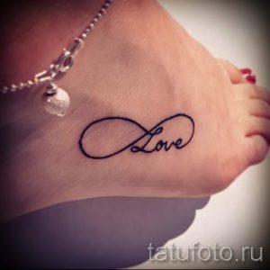 Фото тату: символ бесконечности с надписью 'Love' на лодыжке. Простой и элегантный рисунок татуировки.