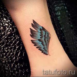 Фото тату: изящное изображение крыла, выполненное в черно-серых тонах, расположено на лодыжке. Детализированная проработка перьев создает реалистичный эффект.