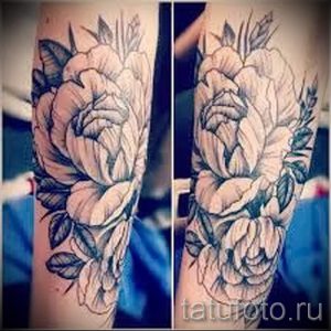 Фото тату: большая татуировка с изображением пышных цветов на предплечье, выполненная в черно-серых тонах. Детализированный рисунок и реалистичные тени.