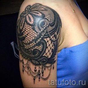 Фото татуировки на плече, выполненной в стиле blackwork с изображением сложного кружевного узора и декоративных элементов. Идеально для ценителей графики.