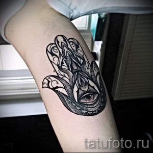 Фото тату Хамса на предплечье. Черно-белый рисунок с детальной проработкой узоров и выразительным глазом в центре ладони.