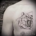 Фото тату на плече: голова медведя, выполненная в геометрическом стиле, с использованием черных линий и точек.