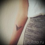 Фото тату на руке в виде треугольника, выполненного точками, минималистичный дизайн.