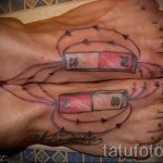 Фото тату батареек на стопах. Оригинальный рисунок татуировки с изображением двух батареек, соединенных проводами, выполненный в реалистичном стиле.