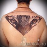 Фото татуировки на спине с изображением головы тигра, заключенной в треугольник, выполненной в технике дотворк. Оригинальный и стильный рисунок.