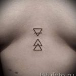 Фото тату: два небольших треугольника, символизирующих элементы, расположены на груди под ключицами.