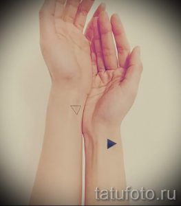 Фото тату: парные татуировки – черный треугольник, направленный вниз, и черный треугольник, направленный вверх, на запястьях. Минималистичные рисунки татуировок для пары.