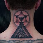 Фото тату: татуировка на задней части шеи, изображающая треугольник с глазом и символом Инь-Янь. Выполнена в черно-серых тонах.
