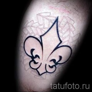 Фото тату минималистичного флер-де-лис на руке. Простой и элегантный рисунок татуировки выполнен в черном цвете.