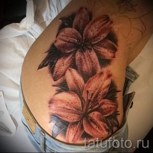 Фото тату лилий на бедре. Черно-серая татуировка с реалистичными деталями, выполненная в стиле реализм. Идеальный эскиз для девушек.