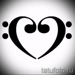 Черно-белое фото тату в виде скрипичного ключа, стилизованного под сердце. Изящный рисунок для любителей музыки и романтики.