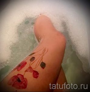 Фотография акварельной татуировки с изображением нескольких маков, словно плавающих в воде. Размытые контуры и нежные оттенки.