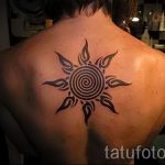 солнце в татуировке на спине - фото