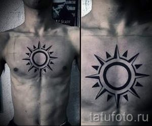 Фотография минималистичной татуировки солнца на груди мужчины. Черно-белый рисунок с четкими линиями и геометрическими формами.