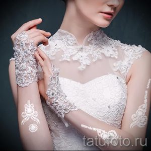 Фото временной татуировки: изящный кружевной узор, имитирующий украшение на руке невесты, выполненный в белом цвете. Идеально для свадебного образа.