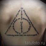 Фото тату на спине: треугольник с символикой Даров Смерти и цитатой из Гарри Поттера. Черный цвет.