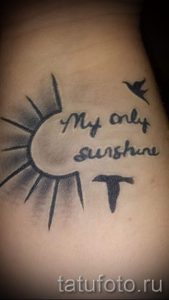 Фото тату солнца, птицы и надписи "My only sunshine" на руке. Черно-серые тона, каллиграфический шрифт.