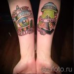 Фотография парных татуировок на предплечьях в стиле олдскул. Изображены горы с глазом, НЛО и надпись 'Time Means Everything'.