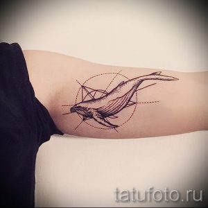 Фото тату: минималистичная татуировка кита, выполненная в технике геометрии. Тонкие линии и геометрические фигуры создают стильный и современный дизайн.