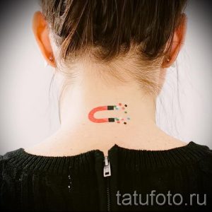 Фото тату магнита на затылке, притягивающего разноцветные точки. Минималистичный дизайн, яркие акценты, оригинальная идея.