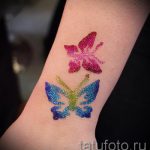 Фото тату с изображением двух разноцветных бабочек, выполненных блестками на коже. Идеально для вдохновения и поиска идей для временных татуировок.