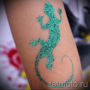 Фото тату ящерицы с блестками на руке. Оригинальный и яркий рисунок татуировки в бирюзовых тонах.