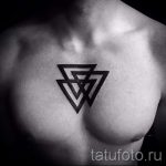 Фото тату: Татуировка на груди из нескольких черных треугольников, расположенных друг внутри друга. Геометрический рисунок татуировки.