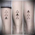Фото трех парных татуировок на ногах, изображающих три небольших треугольника, расположенных вертикально. Разные оттенки серого.