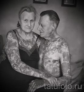 Фото пожилой пары, обнимающейся, с обширными татуировками, покрывающими большую часть их тел.