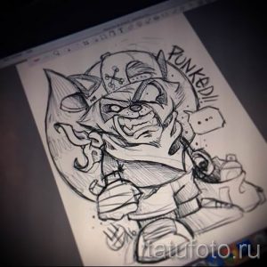 Фото эскиза татуировки енота в стиле панк, с кепкой, наушниками и надписью "Punked!". Черно-белый рисунок.
