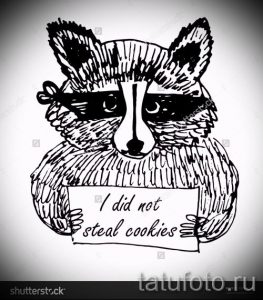 Фото тату енота, держащего табличку с надписью 'I did not steal cookies'. Забавный и оригинальный эскиз для любителей юмора.