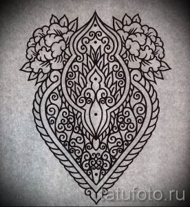 Черно-белый эскиз татуировки в стиле хендмейд с геометрическими узорами и цветочными элементами, расположенный на коже.