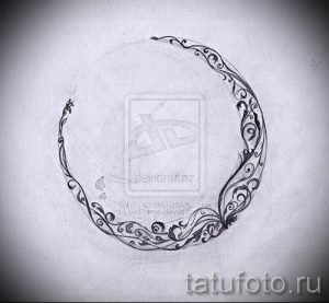 Фотография эскиза татуировки в виде незавершенного круга, украшенного цветочными узорами и листьями. Подходит для женского тела, символизирует красоту и гармонию.