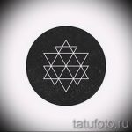 Фото тату: эскиз татуировки, изображающий геометрический узор, заключенный в круг, выполненный тонкими белыми линиями на черном фоне.