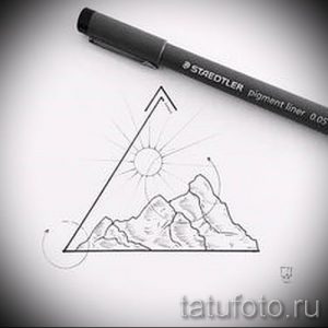 Фото тату: эскиз татуировки, изображающий горный пейзаж с солнцем, заключенный в треугольник, выполненный в графическом стиле.
