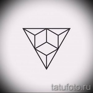 Фото тату: минималистичный эскиз татуировки, изображающий треугольник, внутри которого находится куб, выполненный тонкими черными линиями.