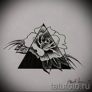 Черно-белый эскиз татуировки с изображением розы, заключенной в треугольник, выполненный в реалистичном стиле с детализированной проработкой лепестков.