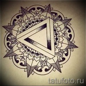 Черно-белый эскиз татуировки в виде мандалы, состоящей из геометрических фигур, включая треугольники и круги, выполненный в технике дотворк.
