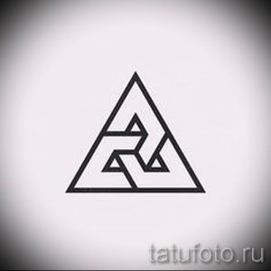 Фотография черно-белой татуировки с изображением треугольника, внутри которого расположены другие геометрические фигуры. Уникальный и сложный рисунок для любителей геометрии.
